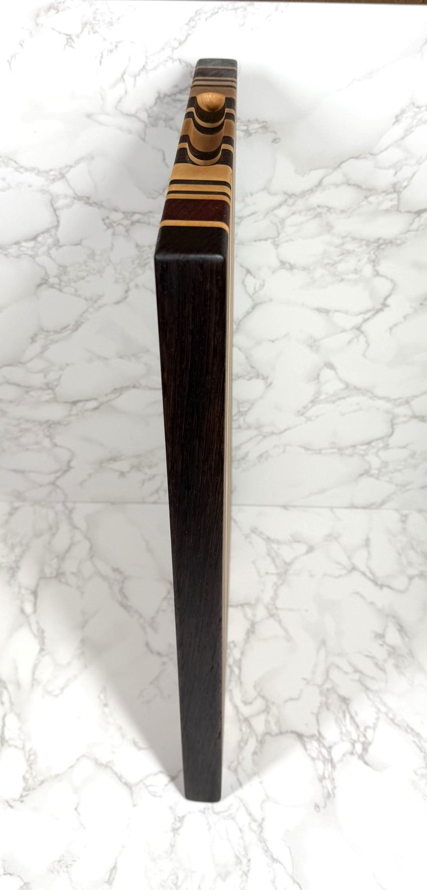 "The OKI 25 – handcrafted cutting board made from Wenge, Black Walnut, Padauk, and Maple."
