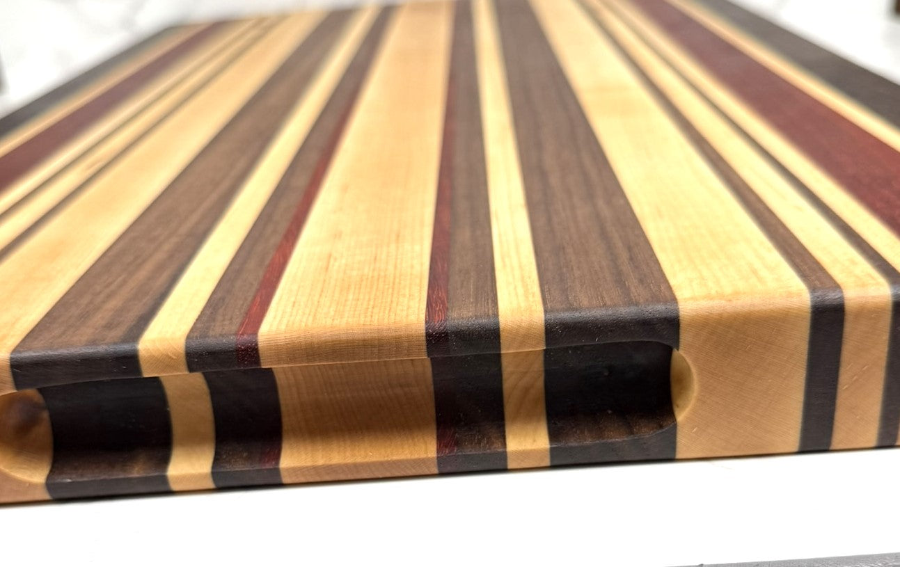 "The OKI 25 – handcrafted cutting board made from Wenge, Black Walnut, Padauk, and Maple."

