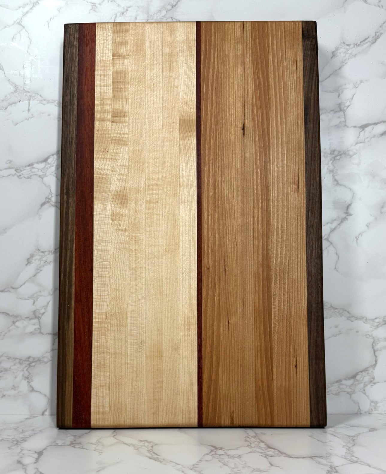 "The Arnold Palmer edge grain cutting board showcasing Black Walnut, Maple, Cherry, and Padauk woods"