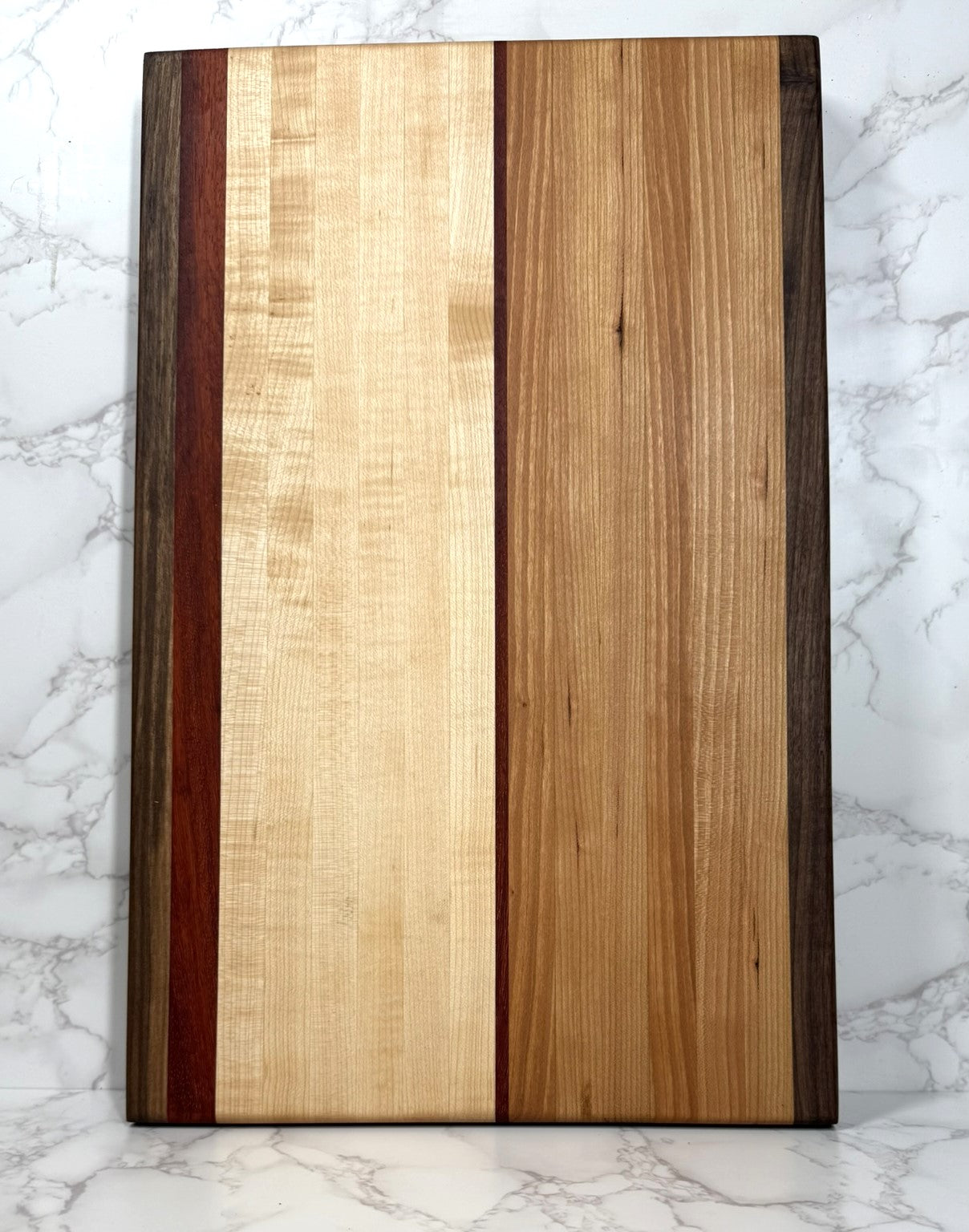 "The Arnold Palmer edge grain cutting board showcasing Black Walnut, Maple, Cherry, and Padauk woods"