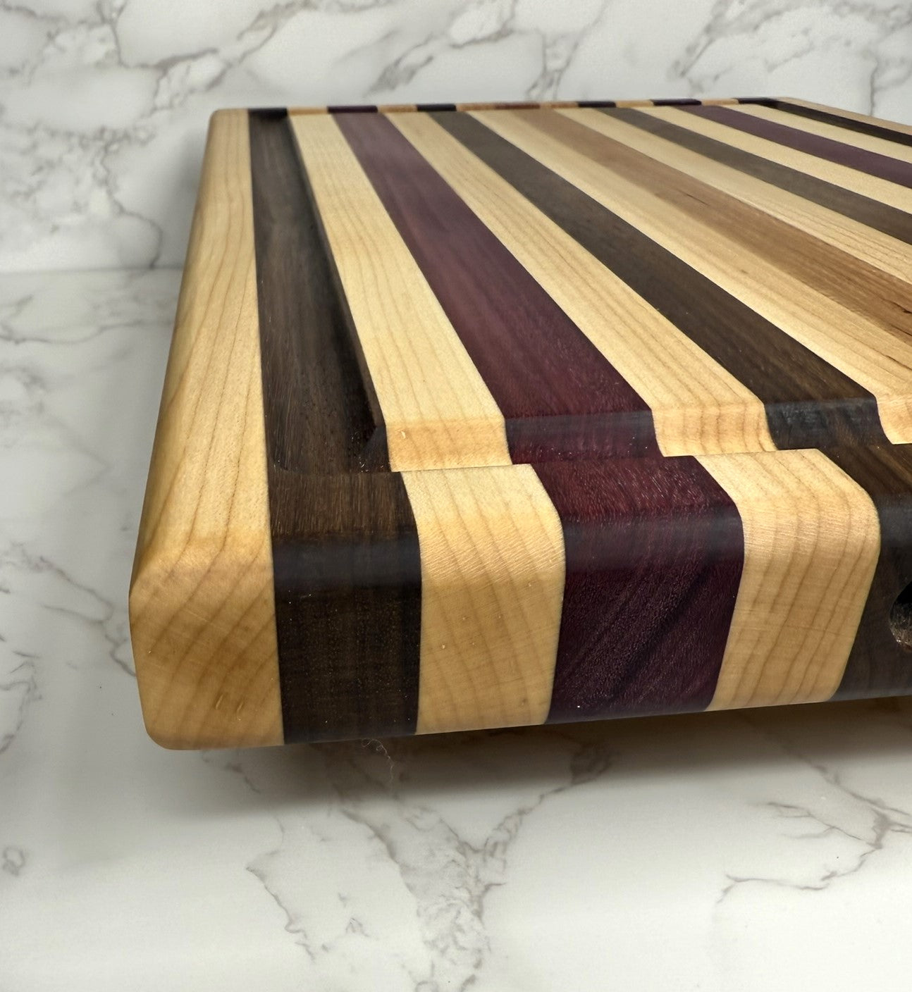 "Light Stripe Edge Grain Cutting Board showcasing Walnut, Maple, Cherry, and Purpleheart woods"