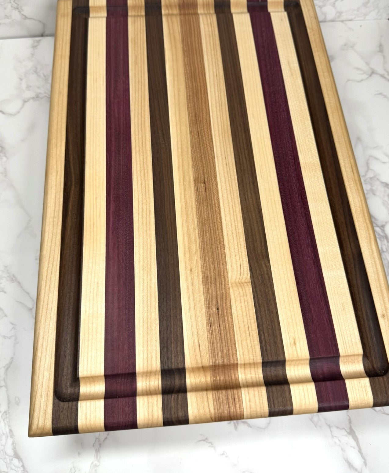 "Light Stripe Edge Grain Cutting Board showcasing Walnut, Maple, Cherry, and Purpleheart woods"