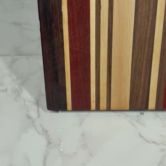 "The OKI 25 – handcrafted cutting board made from Wenge, Black Walnut, Padauk, and Maple."
